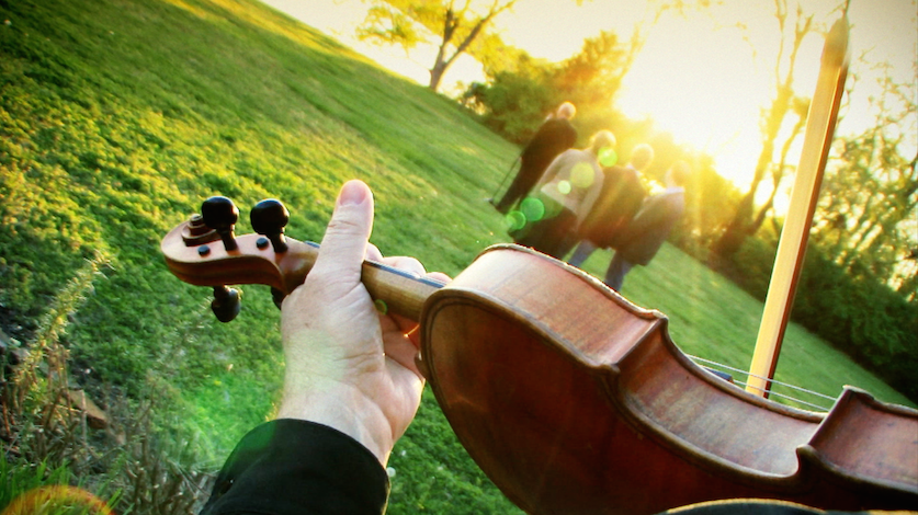 Violin held outdoors at sunset